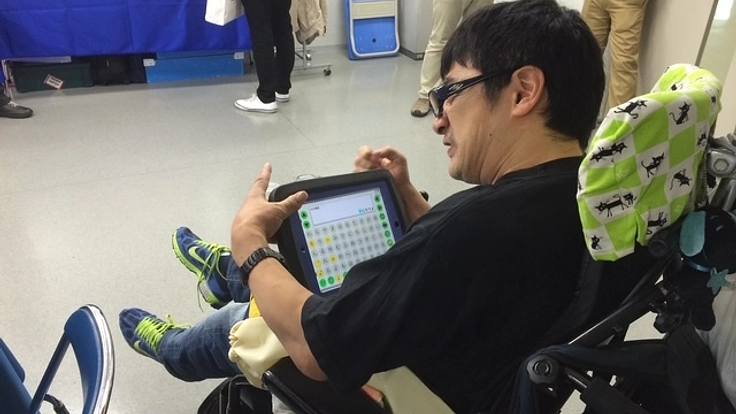 トーキングエイドを操作するメガネをかけた男性